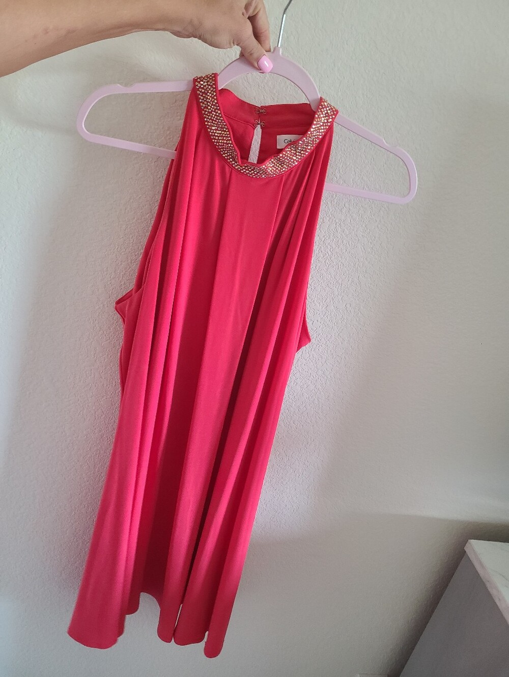 Calvin Klein dress features a flowy halter neckline embellished with jewels